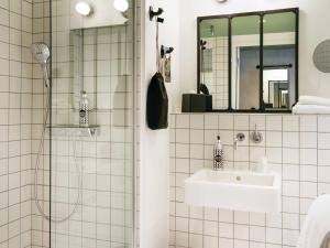 亚眠ibis Styles Amiens Centre的白色瓷砖浴室设有水槽和淋浴