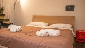 莱切阿波罗套房酒店的一张大床,配有两个枕头和毛巾