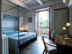 潘札诺Villa Rosa Panzano的一间卧室设有天蓬床和窗户。