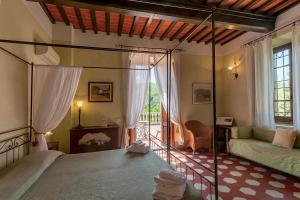 潘札诺Villa Rosa Panzano的一间卧室配有一张床和一个沙发