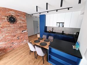 卡托维兹Kima Apartament Bażantów 44的厨房以及带砖墙的用餐室。