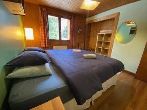 夏蒙尼-勃朗峰B&B Chalet Les Frenes的一间卧室配有一张大床,提供蓝色的床单和枕头