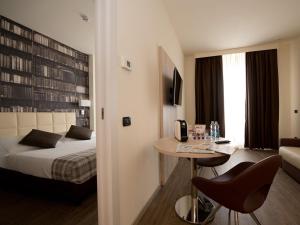 米兰Duomo Hotel & Apartments的酒店客房带一张床、一张桌子和椅子