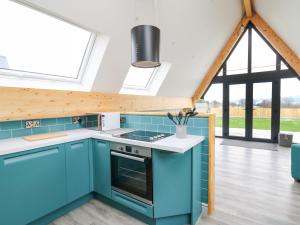 兰德林多德威尔斯Kerry Hill - The Sheepfold的一间设有蓝色橱柜和大窗户的厨房