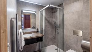 沃雅尼Madame Vacances Hotel Les Cimes的带淋浴和盥洗盆的浴室