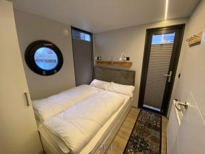 温德托尔夫Hausboot Fjord Luna mit Biosauna in Wendtorf的窗户客房内的小床