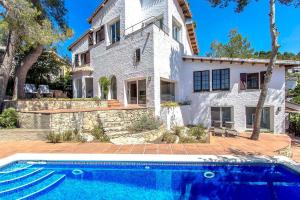 科贝拉罗布里加Catalunya Casas Majestic Villa and Views , 30km to Barcelona的一座大型白色房子,前面设有一个游泳池