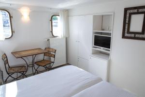 根特船上酒店船屋的一间小卧室,配有一张床和一张桌子及椅子