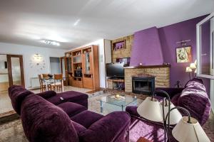 霍斯皮塔勒·德尔英福Catalunya Casas Beach Vibes Villa less than 1km to town and sea!的客厅配有紫色家具和壁炉