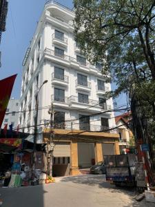 河内Granda Lake View Hotel & Apartment的街道边带阳台的白色建筑