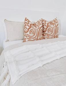 沃纳姆堡The Hideaway - Guest House的白色的床,配有棕色和白色的枕头