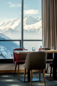 沃雅尼Madame Vacances Hotel Les Cimes的享有雪覆盖山脉美景的用餐室
