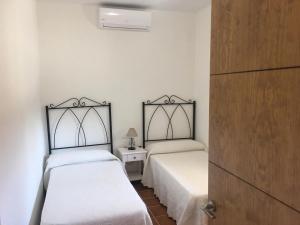 隆达Casa Rural La Maestra的一间卧室设有两张床和床头柜