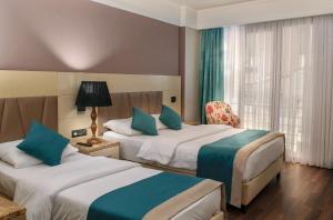 伊斯坦布尔Hotel Bossuite Kadikoy的酒店客房设有两张床和窗户。