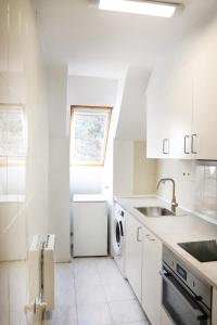 坎弗兰克埃斯塔西翁Apartamento La Campa的白色的厨房配有水槽和洗碗机