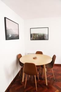 坎弗兰克埃斯塔西翁Apartamento La Campa的白色墙壁的客房内的桌椅