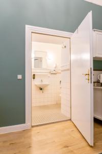 柏林奥利维尔广场公寓式酒店的浴室设有卫生间,水槽通过门