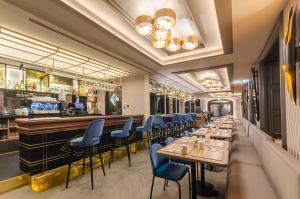 里斯本Eurostars Lisboa Baixa的餐厅设有长条酒吧和蓝色椅子