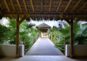锡西Sissi Bay Resort的通往棕榈树建筑的木制走道