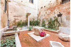 威尼斯La Dogaressa Guest House的一座庭院,里面设有喷泉和鲜花