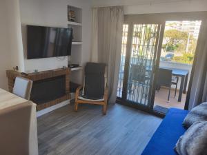 普拉加德阿罗Can Kuqueta, Platja d'Aro的客厅配有平面电视和椅子。