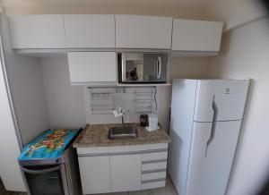 马塞约Apartamento com 2 quartos de FRENTE PARA O MAR的一间带水槽和冰箱的小厨房