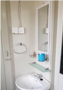 诗巫J & I Homestay B 3 Person with shared bathroom的白色的浴室设有水槽和镜子