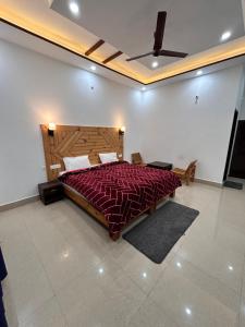 恰克拉塔HOTEL HIMALAYAN FOXHOLE的一间卧室配有一张大床和红色的被子