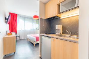 蒙彼利埃蒙彼利埃千禧舒适城市公寓酒店的一个带水槽的厨房和一张位于客房内的床