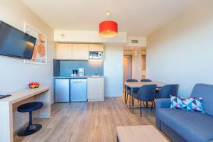 蒙彼利埃蒙彼利埃千禧舒适城市公寓酒店的一间带蓝色沙发的客厅和一间厨房
