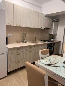 雅西Apartament 2 camere Proximitate Aeroport的厨房配有木制橱柜和桌椅