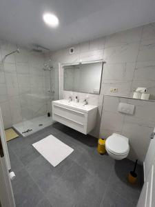 埃尔伯蒙Chez Gina的白色的浴室设有水槽和卫生间。