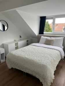 鹿特丹Central Suite Rotterdam的白色卧室设有一张大床和窗户