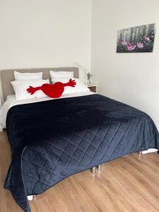 鹿特丹Central Suite Rotterdam的一张带黑色棉被的床,上面有红色的弓