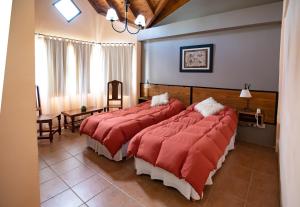 埃尔卡拉法特冰川德拉巴塔哥尼亚酒店的酒店客房,配有两张带红色毯子的床