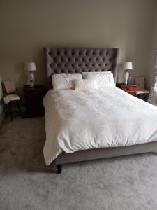 GlinClonoughter Heights的卧室配有一张带白色床单和枕头的大床。
