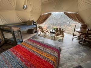 蒙蒂塞洛Blue Mountain Domes - The WOW Experience的帐篷配有一张床和一张桌子及椅子