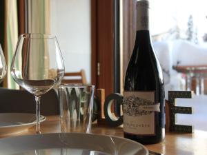 威拉尔-苏-罗伦Studio La Bercière 7 by Interhome的一瓶葡萄酒和一张桌子上的一杯