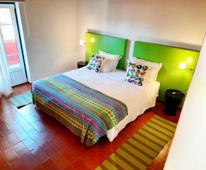 米尔芳提斯城Naturarte Rio - Duna Parque Group的一间卧室配有一张大床,提供色彩缤纷的床单和枕头