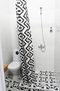 阿克托比Jardin的浴室设有卫生间和黑白淋浴帘。