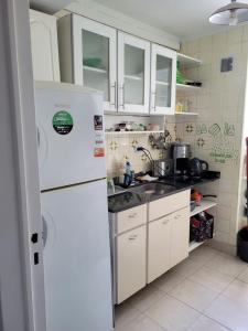 布宜诺斯艾利斯Oasis Lodging的厨房配有白色橱柜和白色冰箱。