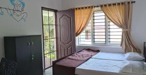 科钦PRAKRITI HOMESTAY Fortkochi Air Conditioned Rooms的一间卧室设有一张床和一个大窗户