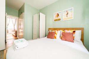 伦敦［FITZROVIA-COVENT GARDEN］CENTRAL LONDON APARTMENT的卧室配有一张带彩色枕头的大型白色床。