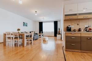 奥多尔黑塞库耶斯克Lotus Apartman II的厨房以及带桌椅的起居室。