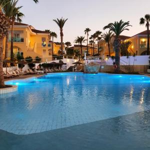 普罗塔拉斯玛拉玛海滩度假酒店的一座棕榈树和建筑的大型游泳池