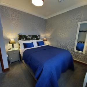 约克Middlethorpe Apartment的一间卧室配有蓝色大床和蓝色床单