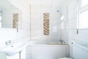 伦敦(Kensington-Olympia-Museums ) Apartment Central London的白色的浴室设有浴缸和水槽。