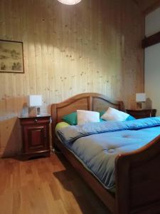 Le NoyerLa Grange的一间卧室配有一张带木制床头板和一张桌子的床。