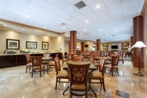 西棕榈滩Hawthorn Extended Stay by Wyndham West Palm Beach的大堂内的餐厅,配有桌椅