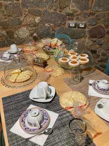 奥尔戈索洛Borgo dei Centenari的一张木桌,上面有盘子和盘子